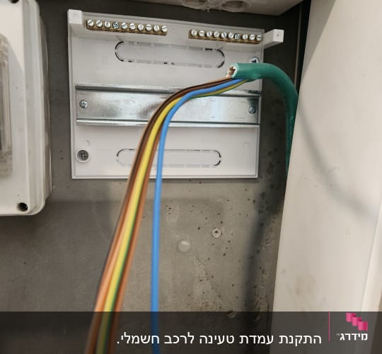 חוטי חשמל צבעוניים מחוברים ללוח חשמל פתוח